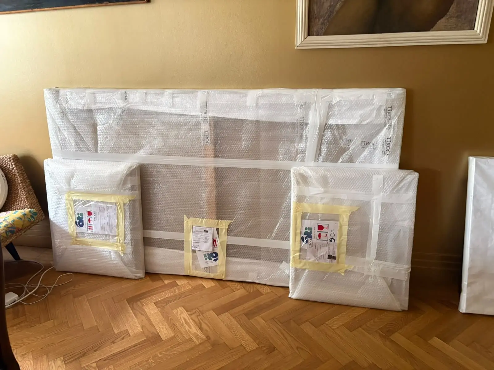 Wrapped artworks leaning against a wall, waiting to be unpacked